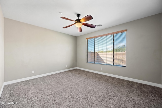 carpeted spare room featuring baseboards, visible vents, and a ceiling fan
