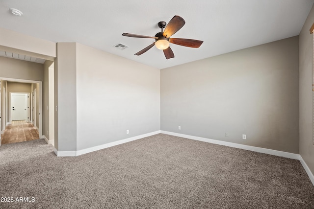 empty room featuring visible vents, a ceiling fan, carpet flooring, and baseboards
