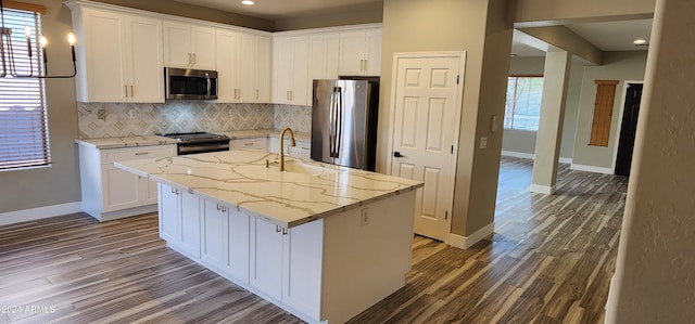 kitchen featuring sink, appliances with stainless steel finishes, a kitchen island with sink, and white cabinetry