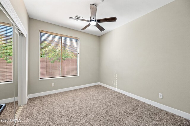 spare room with a ceiling fan, carpet, and baseboards