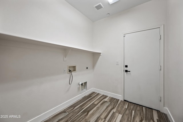 laundry area featuring wood finished floors, laundry area, hookup for an electric dryer, hookup for a gas dryer, and washer hookup