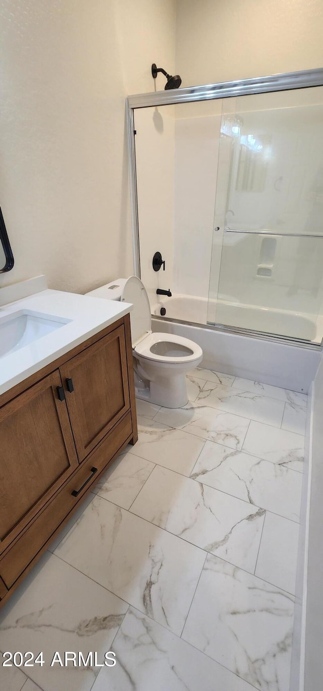 full bathroom with vanity, toilet, and shower / bath combination with glass door