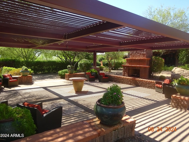 view of patio featuring exterior fireplace and a pergola