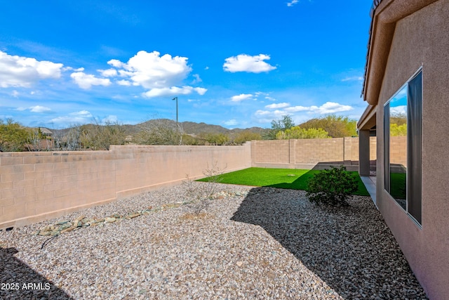 view of yard with a mountain view and a fenced backyard