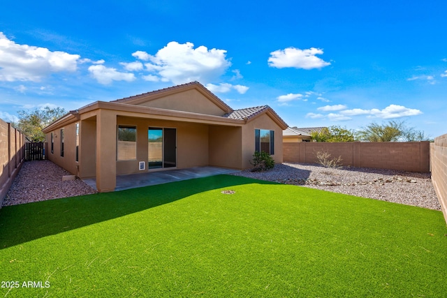 rear view of property featuring stucco siding, a patio area, a lawn, and a fenced backyard