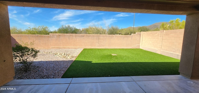 view of yard with a patio area, a mountain view, and a fenced backyard