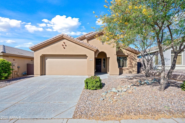 mediterranean / spanish home with a tile roof, stucco siding, driveway, and an attached garage