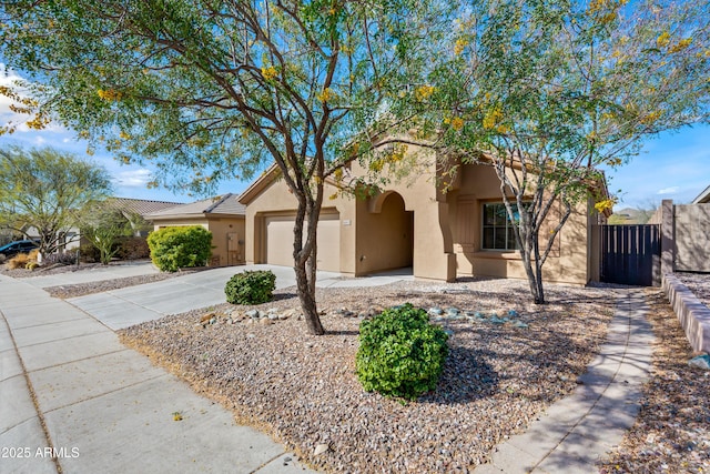 view of front of home featuring stucco siding, fence, concrete driveway, and a garage