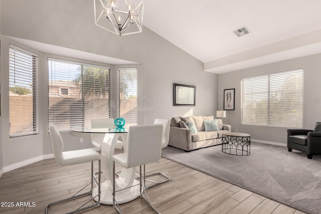 dining area with lofted ceiling and a notable chandelier