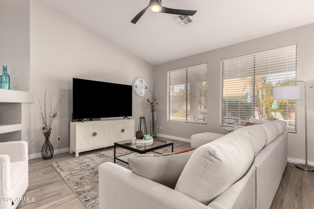 living room featuring ceiling fan, light hardwood / wood-style flooring, and vaulted ceiling