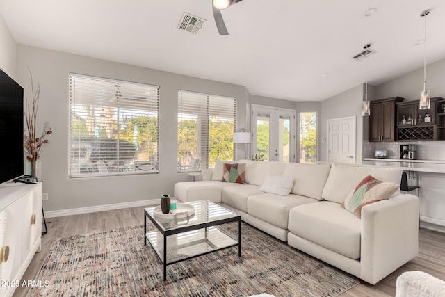 living room featuring ceiling fan, light hardwood / wood-style flooring, and french doors