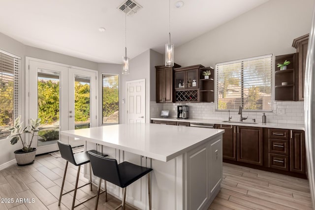 kitchen featuring sink, a center island, decorative backsplash, and lofted ceiling