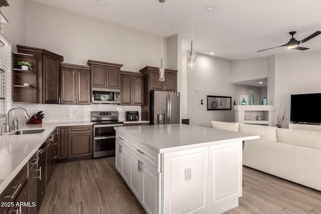 kitchen featuring white cabinets, stainless steel appliances, tasteful backsplash, sink, and light hardwood / wood-style flooring