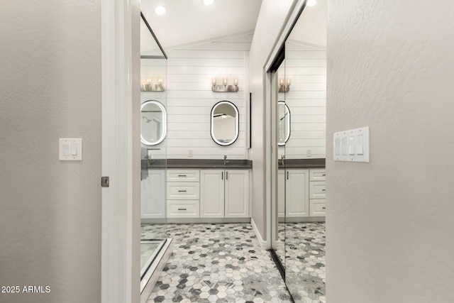 bathroom featuring a shower, lofted ceiling, and vanity