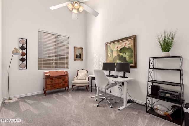 office area featuring a towering ceiling, carpet flooring, and ceiling fan