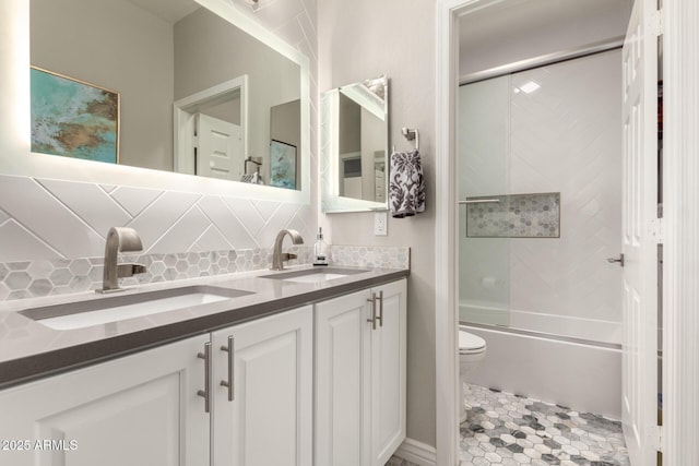 full bathroom with backsplash, toilet, shower / bath combination with glass door, and vanity