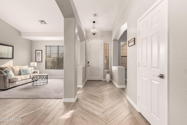 foyer entrance with light hardwood / wood-style floors and a chandelier