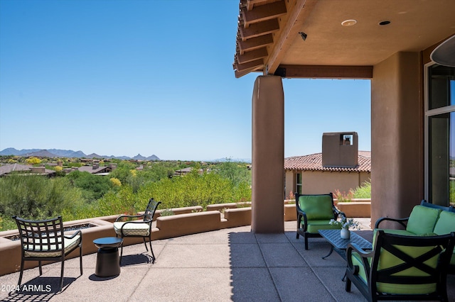 view of patio with an outdoor living space with a fire pit and a mountain view