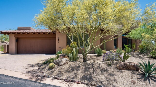 pueblo-style home featuring a garage