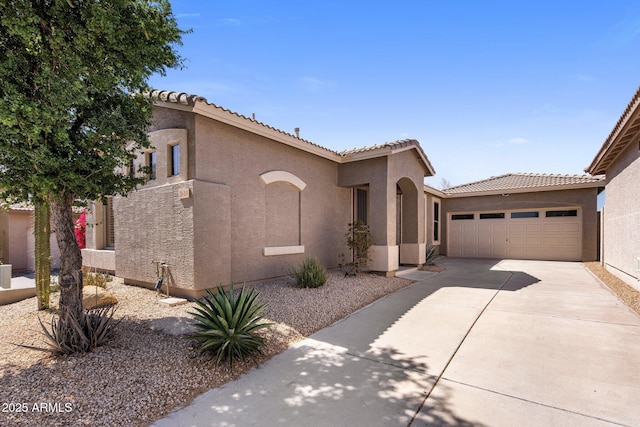 mediterranean / spanish-style home with stucco siding, an attached garage, driveway, and a tiled roof