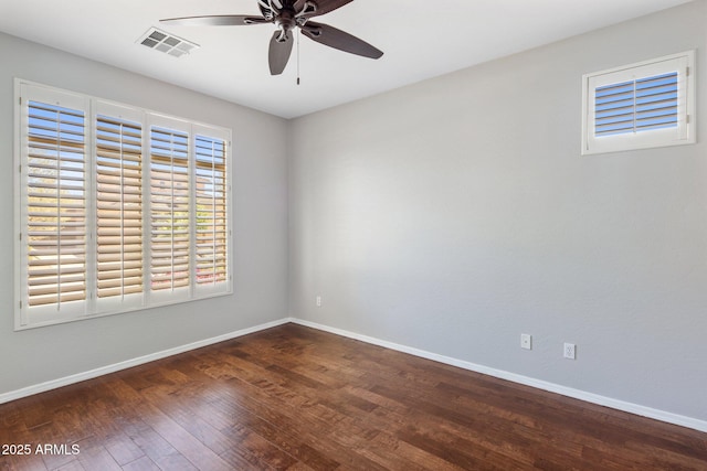 spare room with baseboards, ceiling fan, visible vents, and wood finished floors