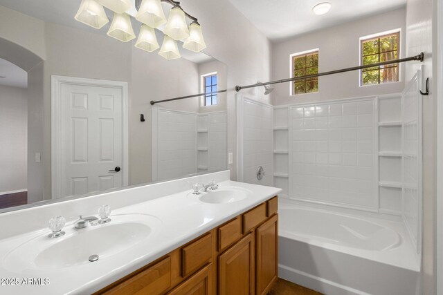bathroom featuring double vanity, shower / bathtub combination, and a sink