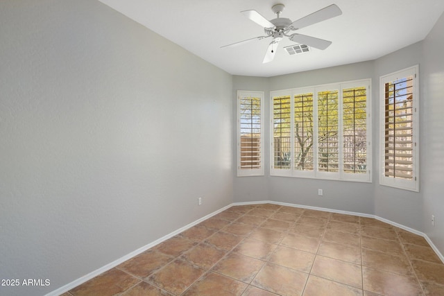 empty room featuring a ceiling fan, baseboards, visible vents, and tile patterned flooring