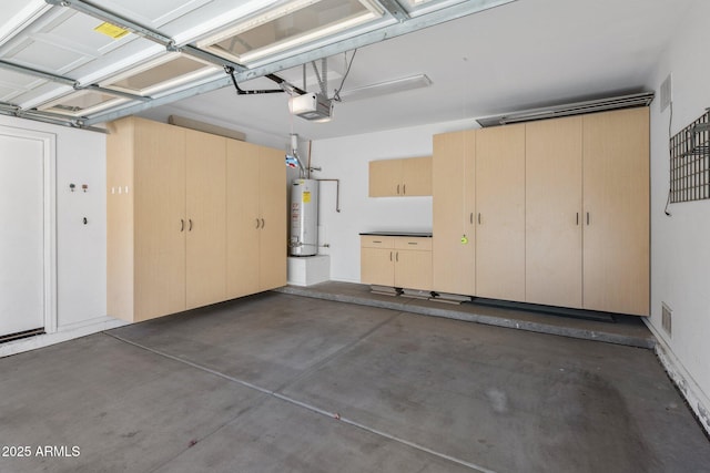 garage with a garage door opener, gas water heater, and visible vents