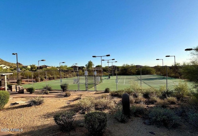 view of tennis court featuring fence
