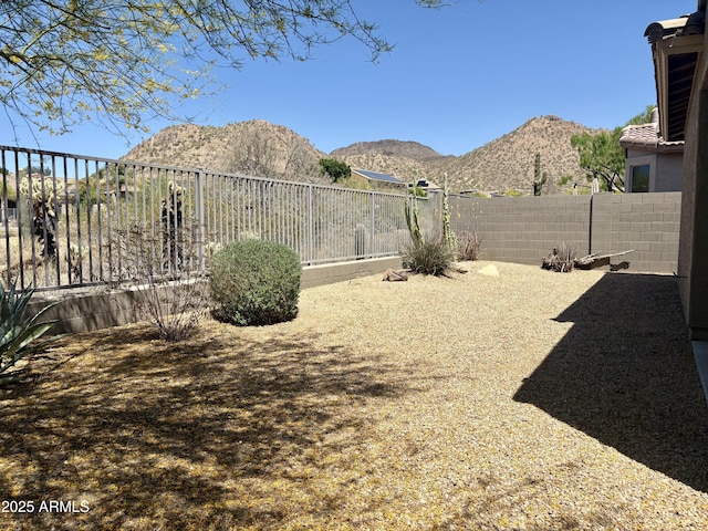 view of yard with a fenced backyard and a mountain view