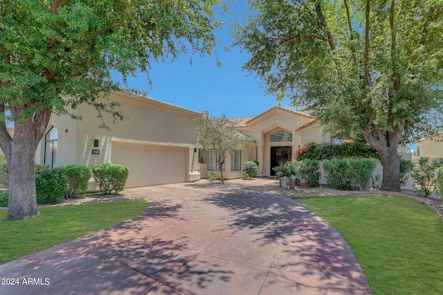 mediterranean / spanish house with a front lawn and a garage