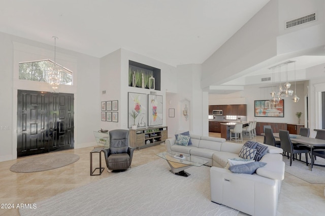 living room with a towering ceiling and an inviting chandelier