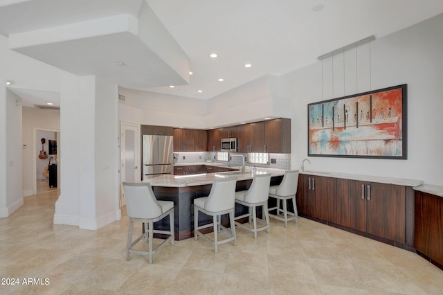 kitchen featuring kitchen peninsula, a kitchen breakfast bar, and stainless steel appliances