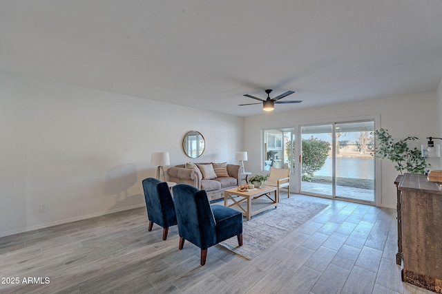 living room featuring ceiling fan and light hardwood / wood-style floors