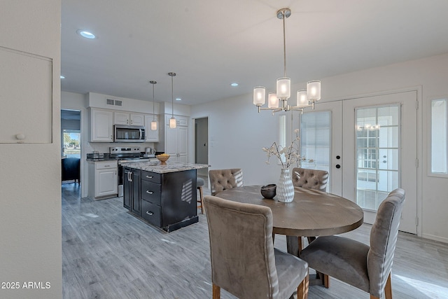 dining space featuring french doors and light wood-type flooring