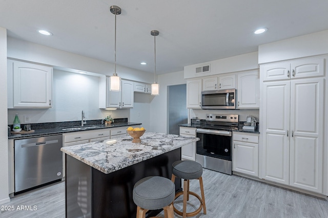 kitchen featuring stainless steel appliances, white cabinetry, sink, and light wood-type flooring