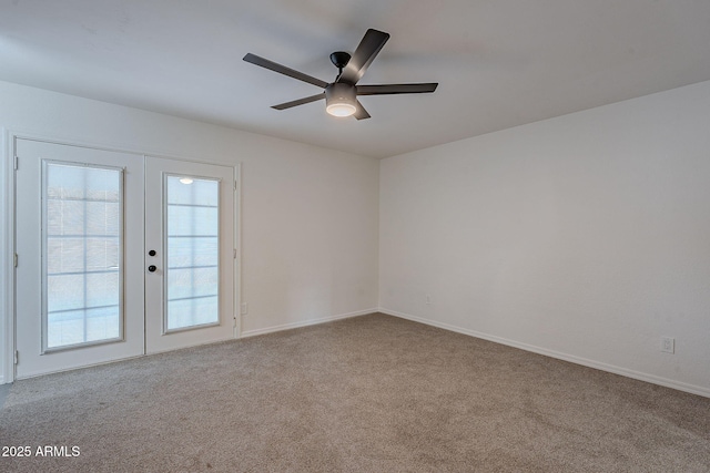 carpeted spare room featuring french doors and ceiling fan