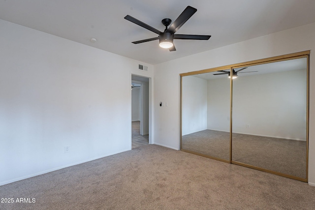 unfurnished bedroom featuring ceiling fan, a closet, and carpet