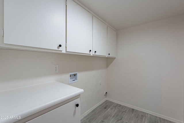 clothes washing area with hookup for a washing machine, light hardwood / wood-style flooring, and cabinets