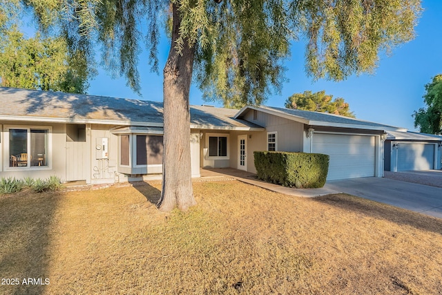 ranch-style home featuring a garage and a front lawn