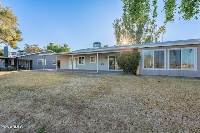 back of house with a yard and a patio