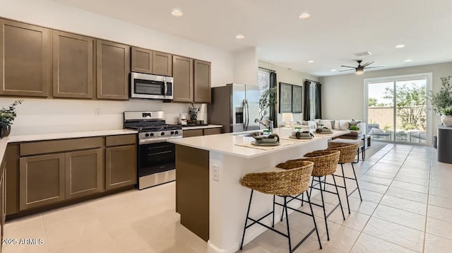 9621 W Monterey Way, Phoenix, AZ 85037 - kitchen with appliances with stainless steel finishes, a kitchen breakfast bar, recessed lighting, light countertops, and an island with sink