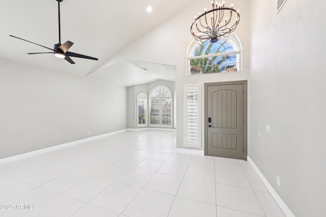 tiled entryway with ceiling fan with notable chandelier and high vaulted ceiling