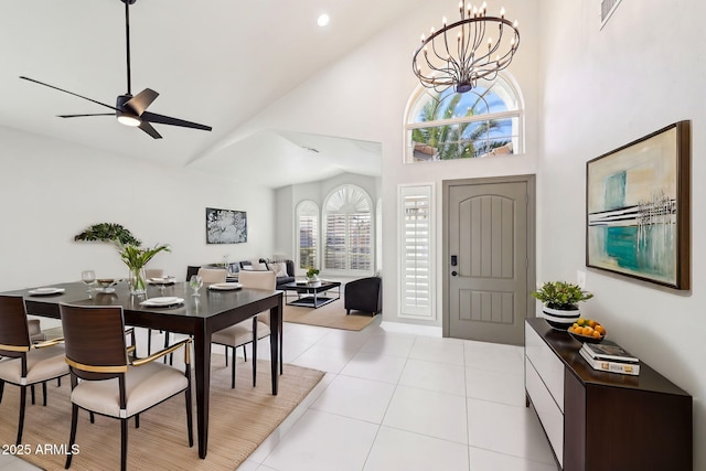 tiled entryway featuring ceiling fan with notable chandelier and high vaulted ceiling