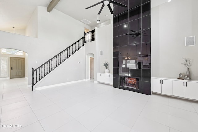 interior space with beam ceiling, light tile patterned flooring, and high vaulted ceiling