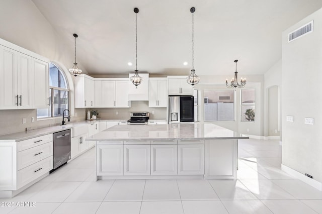 kitchen featuring white cabinets, a center island, pendant lighting, and appliances with stainless steel finishes