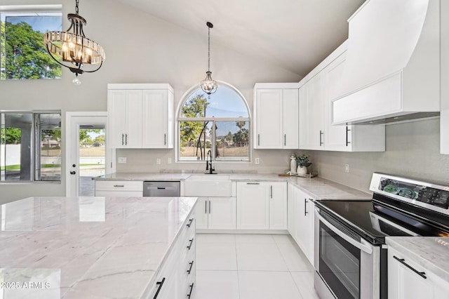 kitchen with white cabinetry, custom range hood, light stone countertops, a chandelier, and appliances with stainless steel finishes