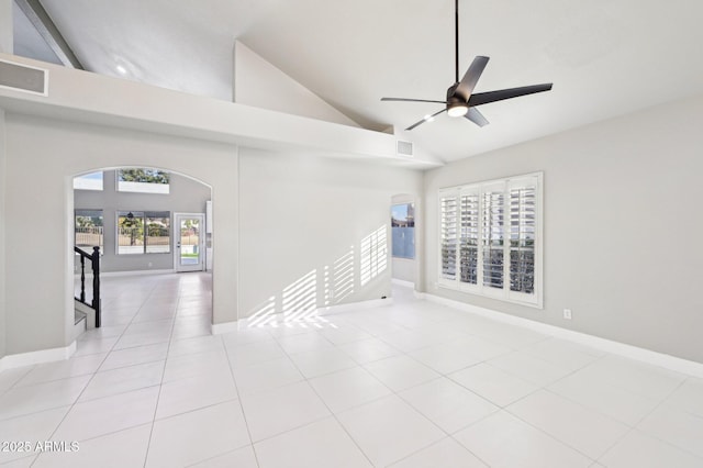 empty room featuring ceiling fan, high vaulted ceiling, and light tile patterned flooring