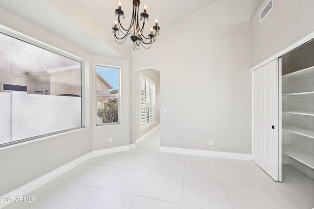 unfurnished dining area with light tile patterned flooring and a notable chandelier