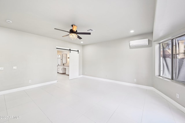 unfurnished room featuring ceiling fan, a wall mounted air conditioner, and a barn door